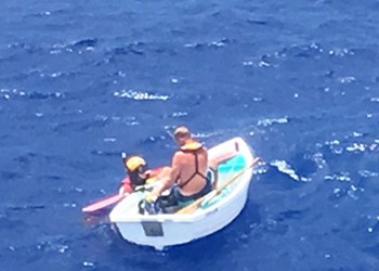 A Coast Guard Rescue Swimmer Prepares a Survivor to be hoisted to Safety After his Boat Sinks 6 miles southwest of Big Sand Cay, Turks and Caicos Islands